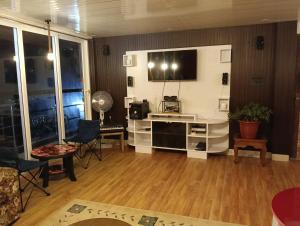 a living room with a television on a wall at Wind chimes villa in Karsiyang