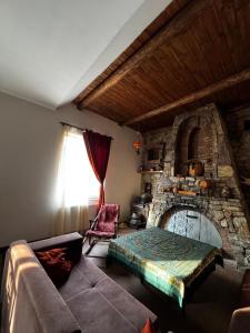 a living room with a stone fireplace and a couch at Vintage Villa Mitskheta in Mtskheta