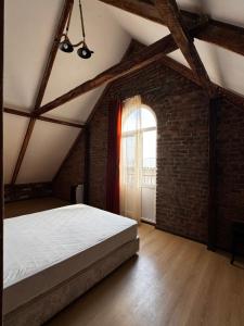 an attic bedroom with a bed and a window at Vintage Villa Mitskheta in Mtskheta