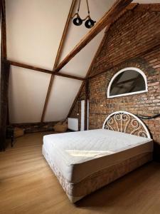a bedroom with a large bed in a brick wall at Vintage Villa Mitskheta in Mtskheta