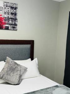 Una cama con una almohada blanca y negra. en Graceful Getaway Home, en Rundu