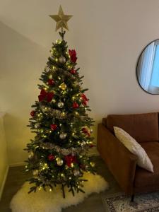 a christmas tree in the corner of a living room at Your Lapland Adventure Base in Rovaniemi