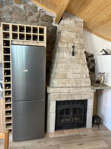 a refrigerator in a kitchen with a stone fireplace at Cantinho da Aldeia in Castedo