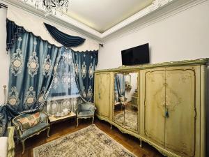 Una sala de estar con un mueble dorado y un televisor. en Conacul Coroanei Luxury Boutique Hotel, en Bucarest