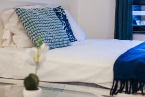 a bed with blue and white pillows on it at Blue Nest Studio - Free Parking and Mountain View in Razlog