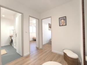 an empty living room with white walls and wood floors at Le Zest d'or - Douceur & Lumière à 5min en voiture de la Plage in Biville-sur-Mer +20 photos