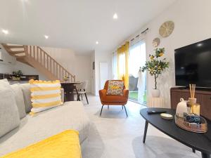 a living room with a couch and a table at Le Zest d'or - Douceur & Lumière à 5min en voiture de la Plage in Biville-sur-Mer