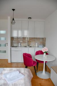 a kitchen with a table and two red chairs at Apartman Boem Pale in Pale