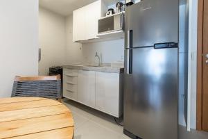 バーハ・デ・サン・ミゲウにあるHarmonia Tropical San Martin - Destino BSM 203 Cのキッチン(ステンレス製の冷蔵庫、テーブル付)