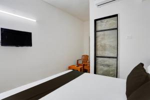 ein Schlafzimmer mit einem Bett und einem Fernseher an der Wand in der Unterkunft Hotel O Sai Shlok Inn Lodging in Nashik + 21 Fotos