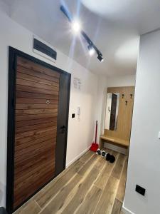 a room with a wooden door and a hallway at Sky Lux Apartments in Jahorina