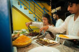 een groep mensen die eten bereiden in een buffet bij Nomazigh Surf House in Tamraght Ouzdar