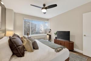 a bedroom with a bed and a flat screen tv at Metro Close - Relax Suite with Massage Chair and Parking in Arlington