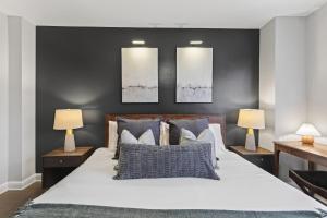 a bedroom with a large bed with two lamps at Metro Close - Relax Suite with Massage Chair and Parking in Arlington +30 photos