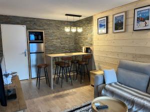 LE CORBIER Vue pistes Studio 5 personnes entièrement rénové في Villarembert: غرفة معيشة بها أريكة وطاولة