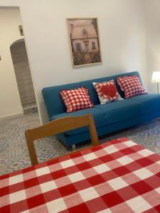 een blauwe bank met rode en witte kussens in de woonkamer bij Laura's Cottage in Calatabiano