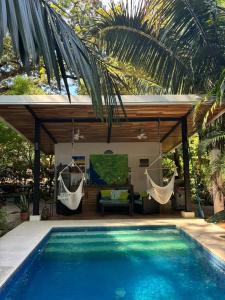a villa with a swimming pool and a hammock at Casitas Escondidas in Playa Pelada