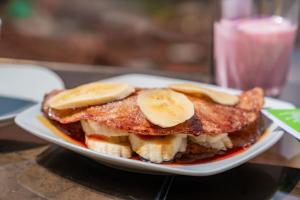 una pila de panqueques con plátanos en un plato en Hostal Casa Del Inka, en Cusco 105 fotos más
