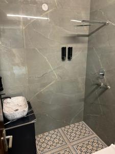 una ducha con puerta de cristal en un baño en The Luxe, en Jāmb