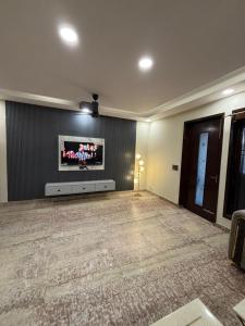 Una sala de estar con un televisor de pantalla plana en una pared. en The Luxe, en Jāmb