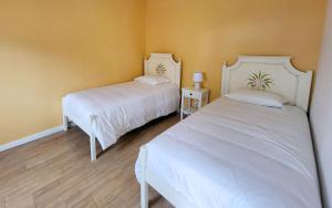 two white beds in a room with yellow walls at Casa Elvas Antiqua in Elvas