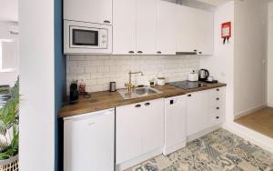 une cuisine blanche avec un évier et un micro-ondes dans l'établissement Casa Elvas Antiqua, à Elvas