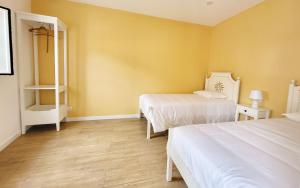 deux lits dans une chambre aux murs jaunes et au parquet dans l'établissement Casa Elvas Antiqua, à Elvas