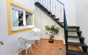 a room with a staircase and two chairs and a table at Casa Elvas Antiqua in Elvas