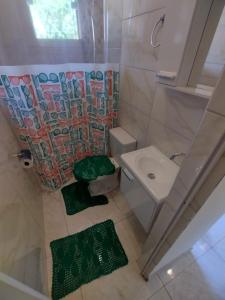 um pequeno banheiro com um vaso sanitário e uma pia em Kitnet dos netos em Ubatuba mais 18 fotografias