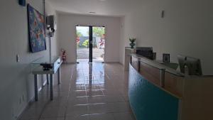 a room with a hallway with a counter and a door at Capri Hotel in São Francisco do Sul