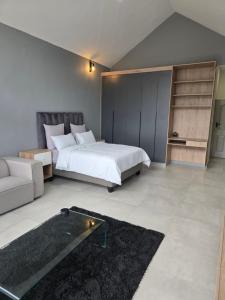 a large bedroom with a bed and a couch at WeThusi stream in Mbabane