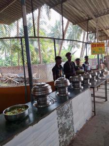 a group of men standing behind a counter with food at Dreamworld Waterpark Resort Virar in Virār
