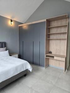 ein Schlafzimmer mit einem Bett und einem Bücherregal in der Unterkunft iThusi stream in Mbabane