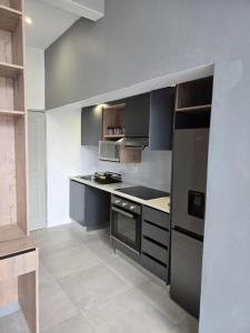 eine Küche mit schwarzen und weißen Arbeitsflächen und Geräten in der Unterkunft iThusi stream in Mbabane + 6 Fotos