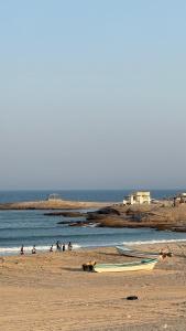 un barco en una playa con gente en el agua en فلة الشروق - Sunrise Villa, en Sur