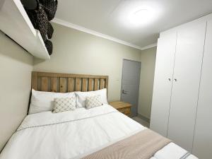 29 on Windsor-2 Bedroom House في Silver Sands: غرفة نوم بها سرير مع ملاءات ووسائد بيضاء