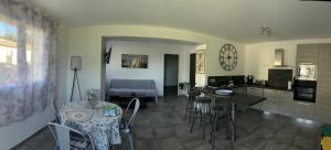 a kitchen and a living room with a table and chairs at Chez Suzanne in Corbara