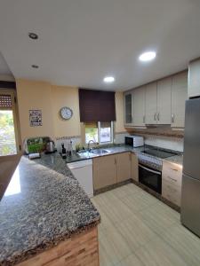 a large kitchen with white cabinets and granite counter tops at sol y arena in Santa Pola