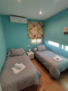 two beds in a room with blue walls at sol y arena in Santa Pola