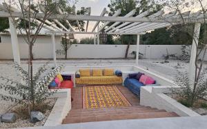 a couch sitting under a pergola in a backyard at Al Ain Farm Escape with Private Pool , Mini Golf , and Firepit in Bin Aḩmad