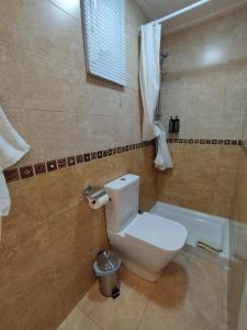 a bathroom with a white toilet and a shower at sol y arena in Santa Pola +18 photos