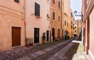 an empty alley in an old city with buildings at Grand Suite Gioberti Elegante nel cuore di Alghero in Alghero