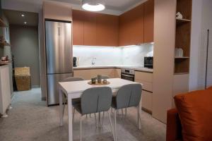 VASIADIS apartment في Síndos: مطبخ مع طاولة وكراسي وثلاجة +13 صورة