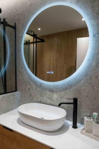 a bathroom with a large white sink and a mirror at VASIADIS apartment in Síndos