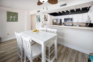 a white kitchen with a white table and chairs at Gulf Side 402 Pet friendly gulf front condo in Fort Walton Beach +25 photos
