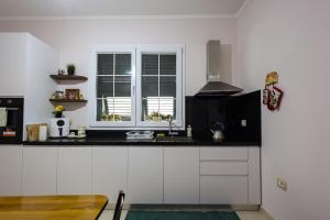 a kitchen with white cabinets and a black counter top at Apartment with garden in the center of Durres in Durrës