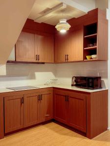 een keuken met houten kasten en een magnetron bij Florent House in Chiang Mai