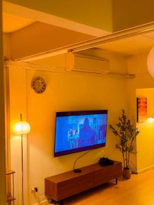 een woonkamer met een flatscreen-tv aan de muur bij Florent House in Chiang Mai