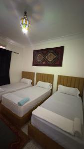 duas camas num quarto com um lustre em Les appartements de la Koutoubia em Marraquexe