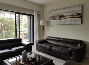 Una sala de estar con un sofá de cuero y una mesa. en Riverside Square, en Nairobi
